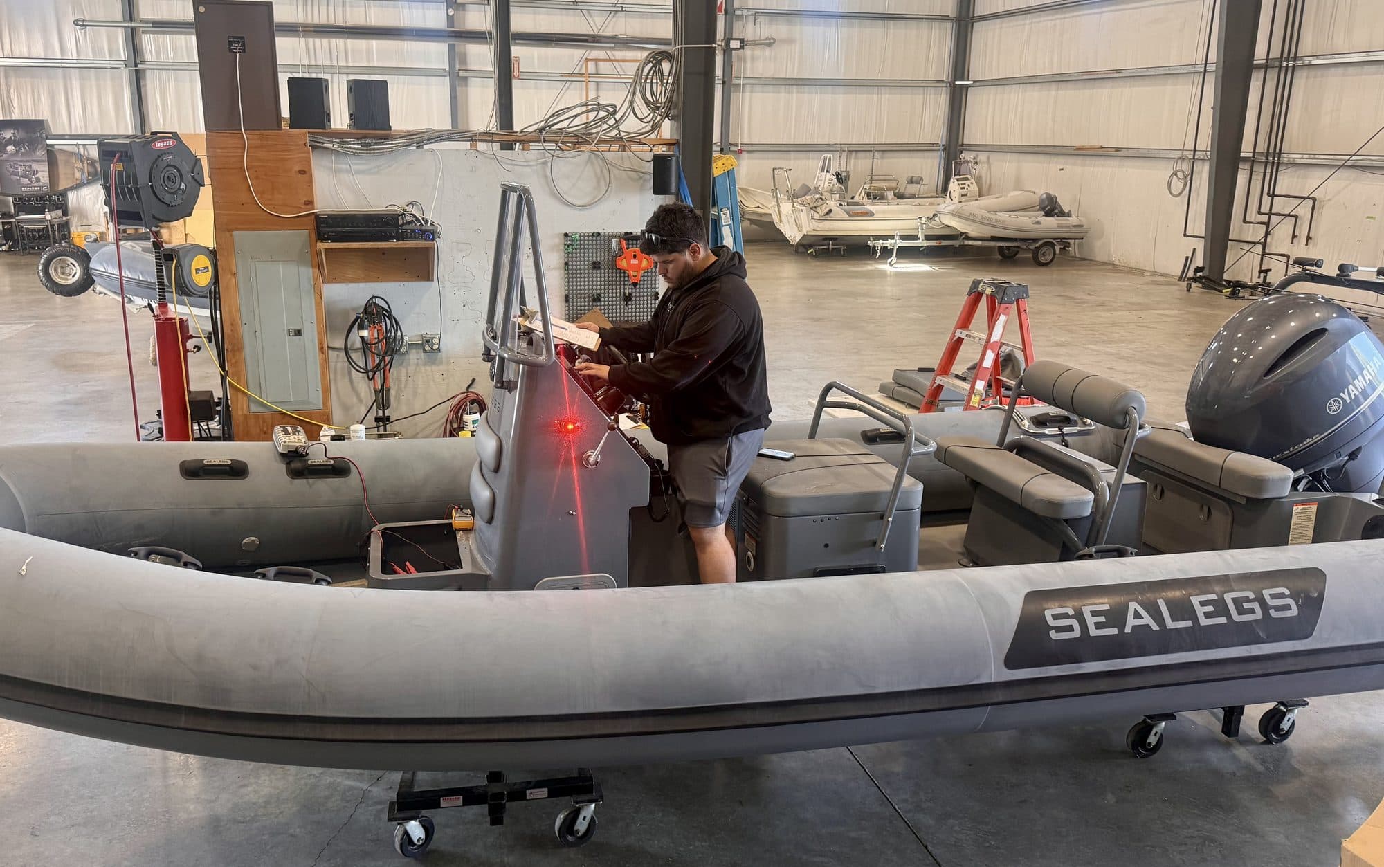 A technician at work alongside the tube of a Sealegs RIB in the Bristol workshop