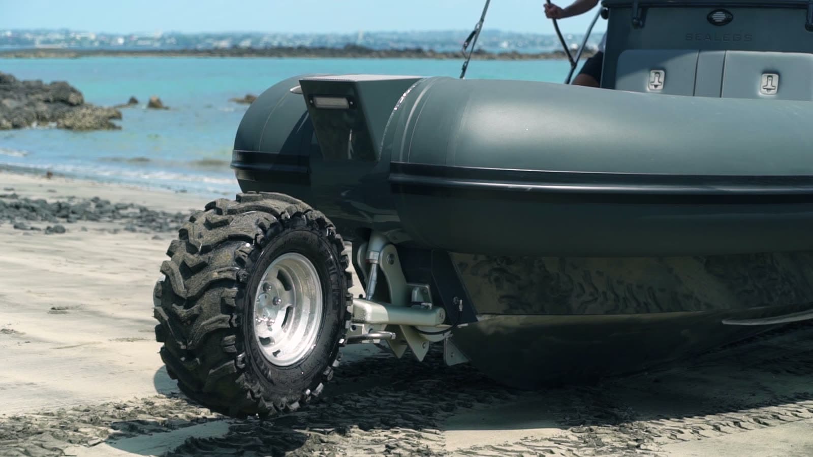 A Sealegs 9m Hydrasol RIB on a beach, wheels down on the shore